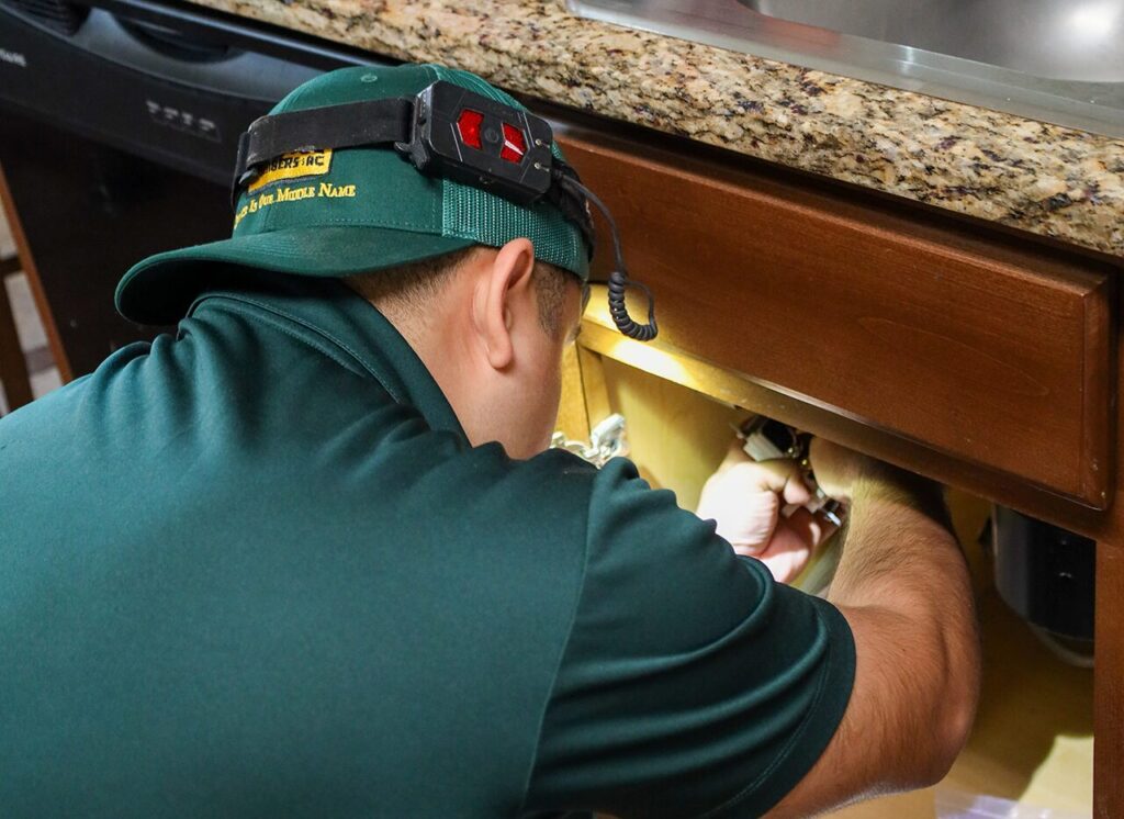 Public Service Plumbers Plumbing Services in Dallas, TX Plumber repairing under-sink plumbing in a Dallas, TX home