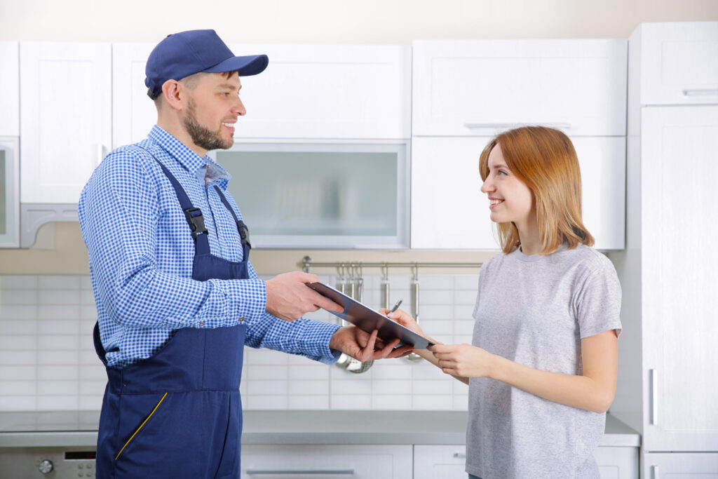 Woman-signing-receipt-for-plumber-service-at-home